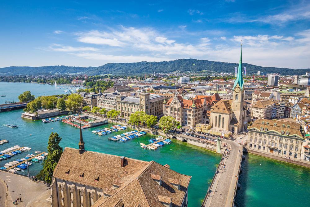 Luftbild des historischen Zentrums von Zürich mit der berühmten Fraumunster Kirche und dem Fluss Limmat am Zürichsee von der Grossmunster Kirche an einem sonnigen Tag mit Wolken im Sommer, Kanton Zürich, Schweiz