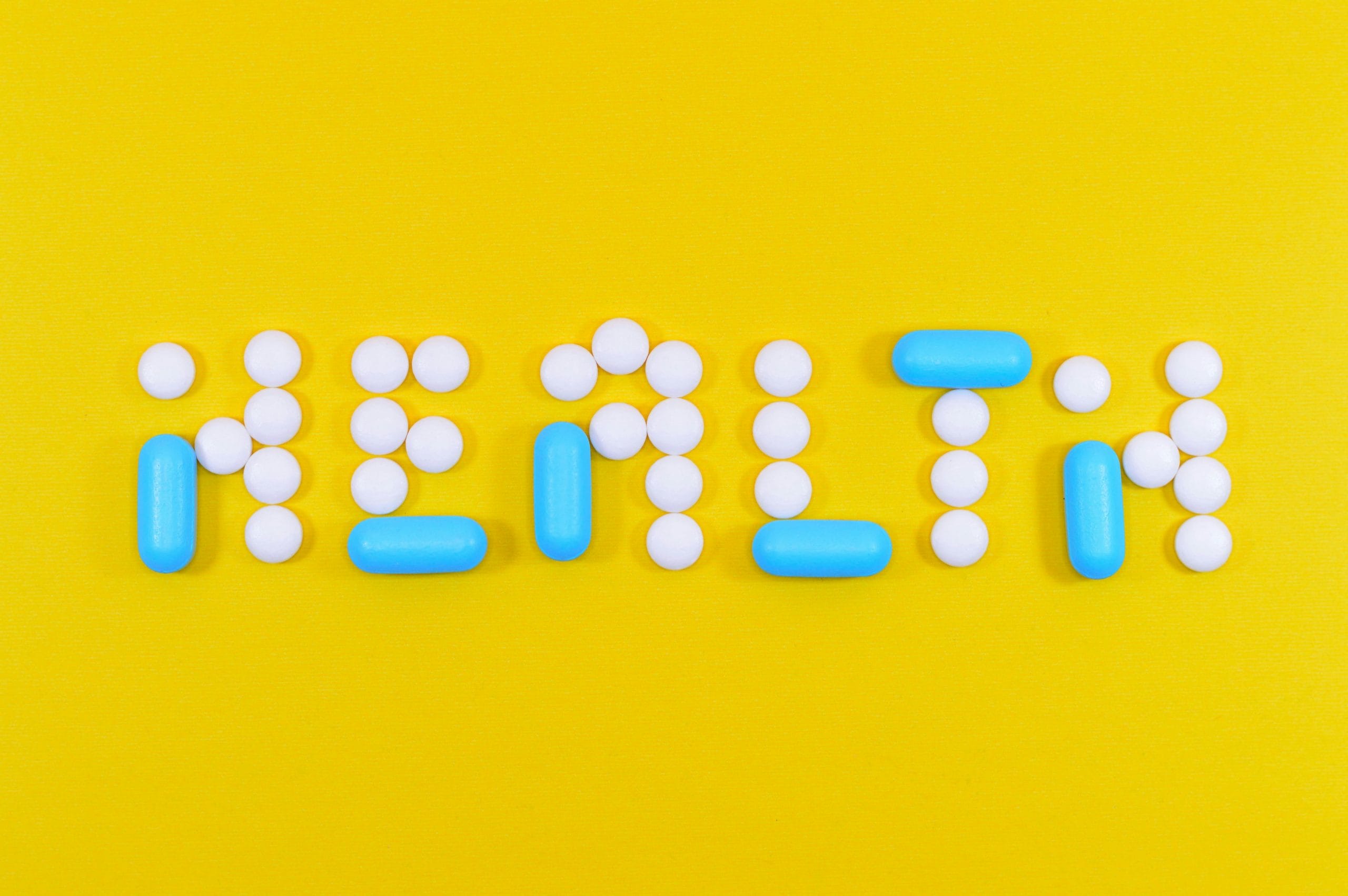 Symbolische Darstellung von Gesundheit mit rezeptfreien Schmerzmitteln in Tabletten- und Kapselform auf gelbem Hintergrund. Passend für Themen wie rezeptfreie Schmerzmittel und Gesundheitstipps.