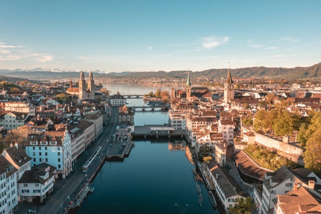 Zürich am Morgen mit Limmat, Altstadt, Zürichsee und Alpen im Hintergrund